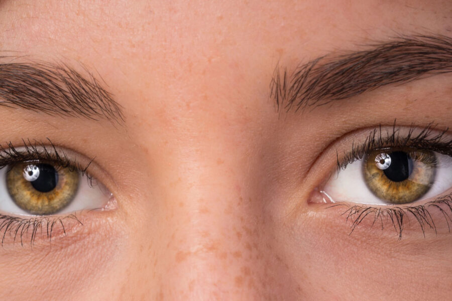 Eine Nahaufnahme der Augen einer Person mit natürlichen Wimpern und Augenbrauen, die das Problem des Haarausfalls in diesen Bereichen veranschaulicht.